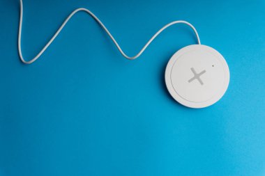 Mavi arkaplanda şarj pedi ya da rıhtım. Kablosuz şarj ve kopyalama alanı 