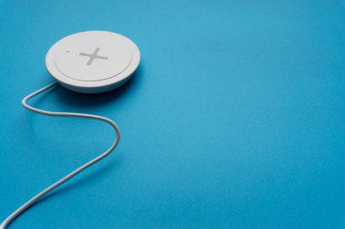 Mavi arkaplanda şarj pedi ya da rıhtım. Kablosuz şarj ve kopyalama alanı 