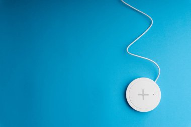 Mavi arkaplanda şarj pedi ya da rıhtım. Kablosuz şarj ve kopyalama alanı 