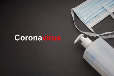 Antibakteriyel sabun dezenfektanı ve siyah arka planda koruyucu yüz maskesi olan koronavirüs metni. Covid-19 veya Coronavirus Kavramı 