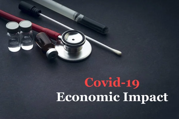 COVID-19 or CORONAVIRUS ECONOMIC IMPACT text with stethoscope, medical swab and vial on black background. Covid-19 or Coronavirus concept.