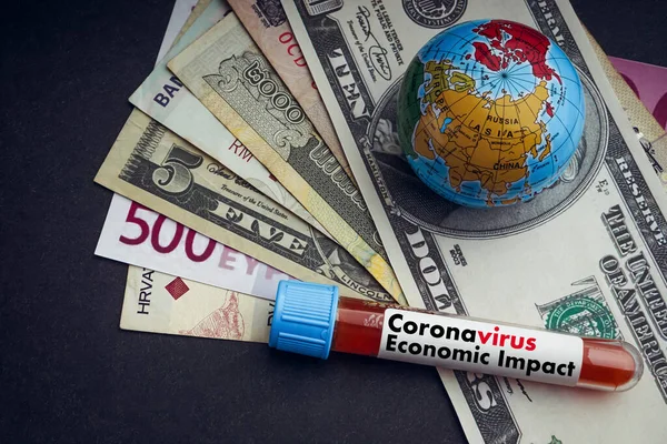 CORONAVIRUS ECONOMIC IMPACT text with currency banknotes, world globe and blood test vacuum tube on black background. Covid-19 or Coronavirus Concept