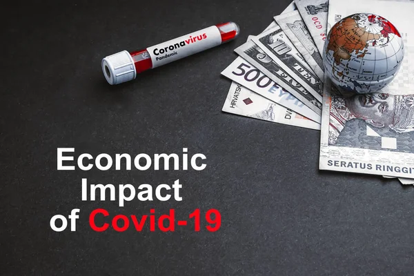 ECONOMIC IMPACT OF COVID-19 text with currency banknotes, world globe and blood test vacuum tube on black background. Covid-19 or Coronavirus Concept