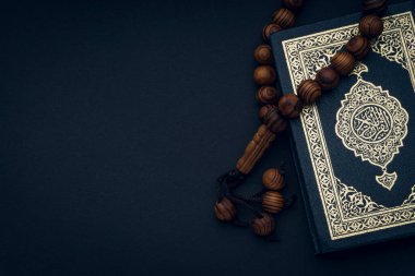 Al-Kur 'an' ın Arapça el yazısı ve siyah arkaplanda tespih ya da tasbih anlamına gelen kutsal Kur 'an. Boşluk ve kırpma parçalarını kopyala