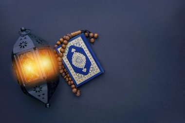 El-Kur 'an anlamına gelen Arapça el yazısı, fener lambası, tespih ya da siyah arkaplan üzerine tasbih içeren kutsal Kur' an..