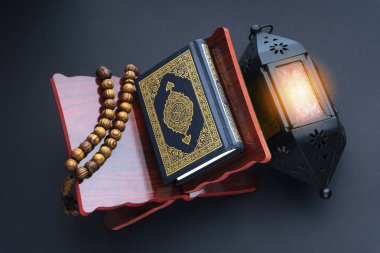 El-Kur 'an anlamına gelen Arapça el yazısı, fener lambası, tespih ya da siyah arkaplan üzerine tasbih içeren kutsal Kur' an..