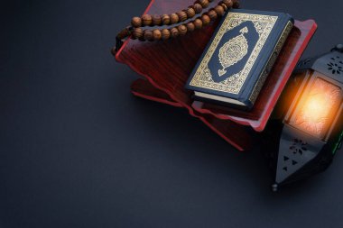 El-Kur 'an anlamına gelen Arapça el yazısı, fener lambası, tespih ya da siyah arkaplan üzerine tasbih içeren kutsal Kur' an..