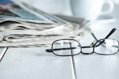Gazeteler ve gözlük yığını