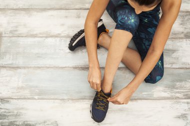 Ahşap arka plan üzerinde oturan sportif genç kadın