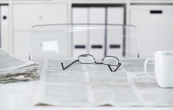 Periódicos con anteojos en la mesa — Foto de Stock