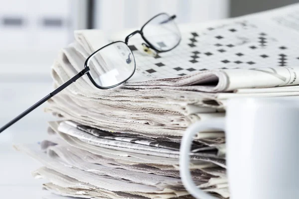 Newspapers with eyeglasses on table — Stock Photo, Image