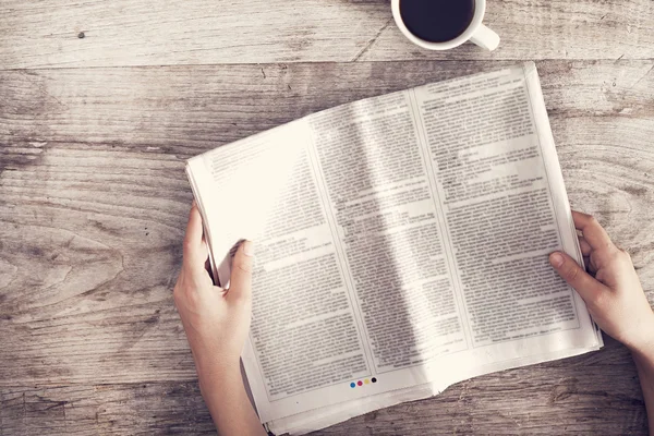 Young woman reading newspaper