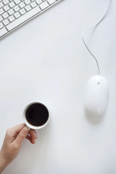 Mano sosteniendo café en la mesa de oficina —  Fotos de Stock