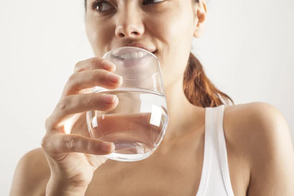 Jeune femme boire un verre d'eau — Photo