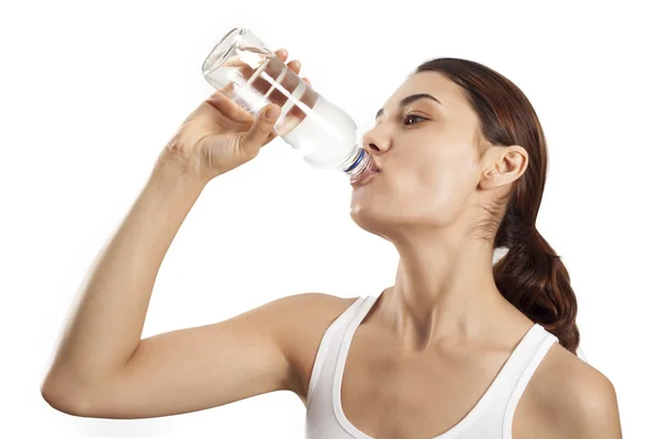 Молода жінка п'є пляшку води — стокове фото