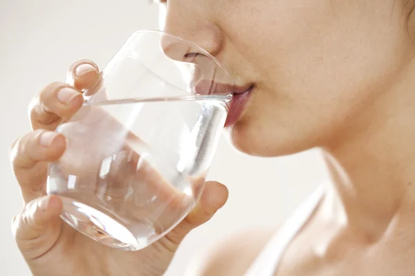 Jeune femme boire un verre d'eau — Photo