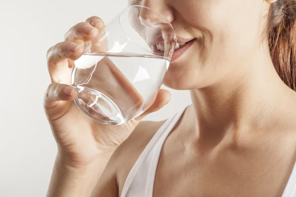 Jeune femme boire un verre d'eau — Photo