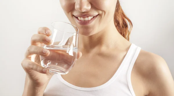 Jeune femme boire un verre d'eau — Photo