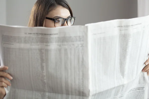 Joven mujer leyendo periódico — Foto de Stock