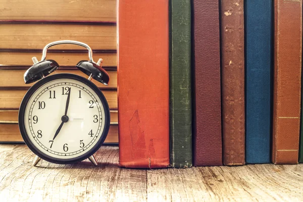 Yığın saat üstünde okul sırası ile kitap