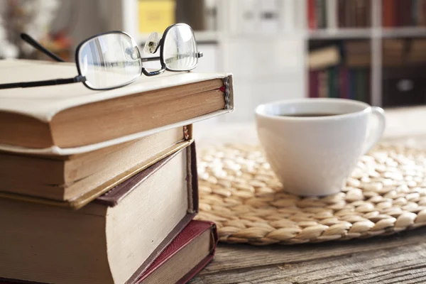 Pile of books with reading glasses on desk — Stock Photo, Image