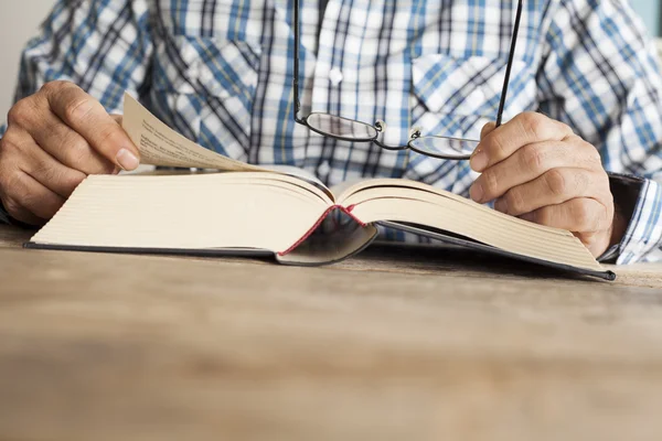 Hombre leyendo libro en la mesa — Foto de Stock