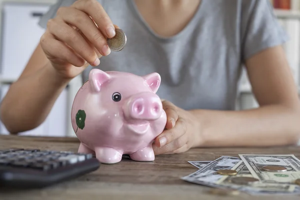 Putting coin in piggy bank — Stock Photo, Image