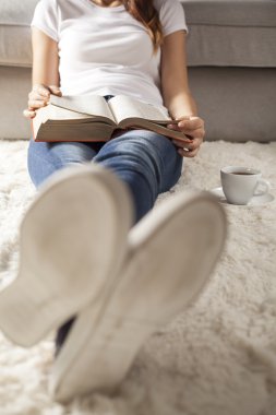 Genç kadın kahve ile kitap okuma