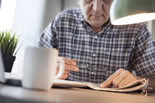 Homem lendo jornal na mesa — Fotografia de Stock