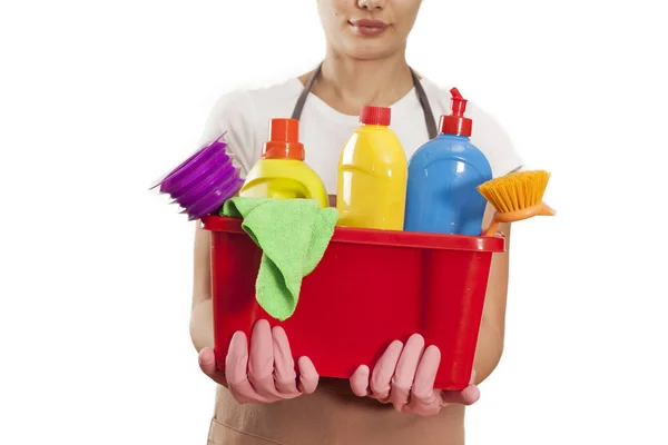 Young woman with cleaning supplies on white background — Stock Photo, Image