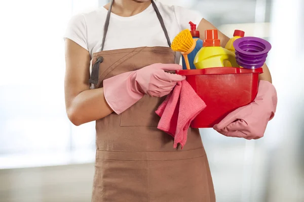 Mulher com suprimentos de limpeza em casa — Fotografia de Stock