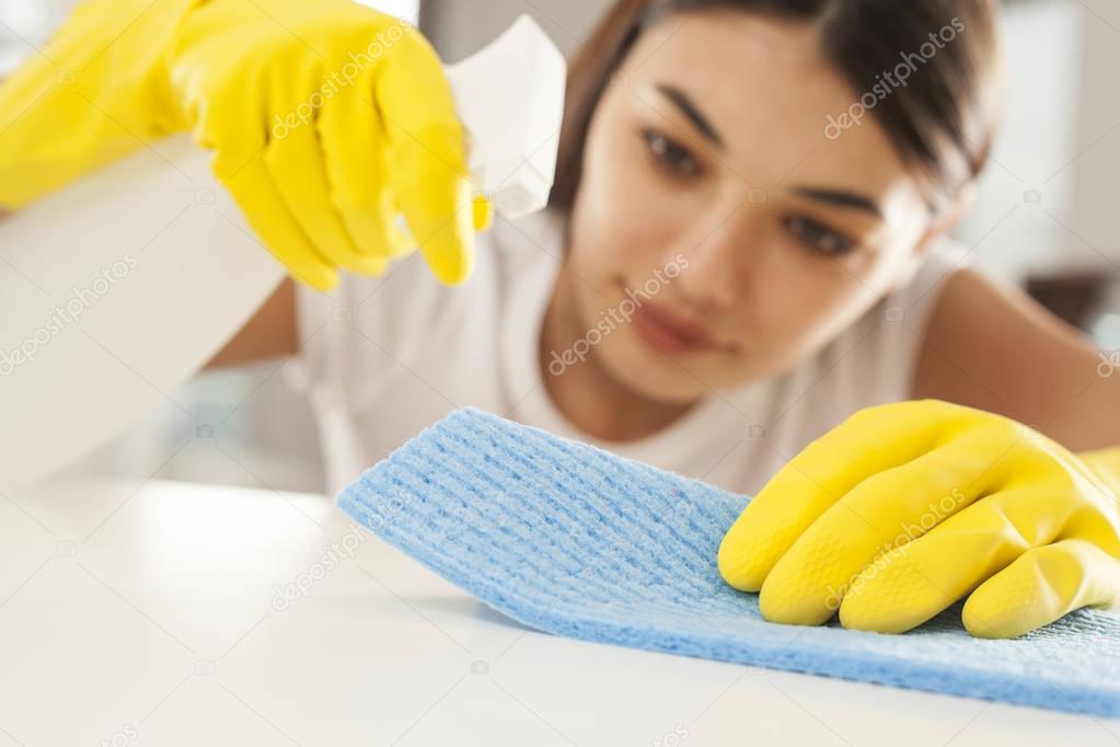 Young woman cleaning on table