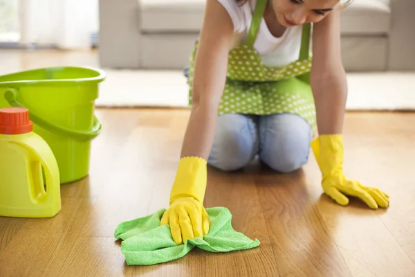 Vrouw met doek schoonmaken van de vloer in huis — Stockfoto