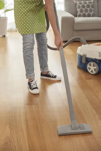 Vrouw reiniging van de vloer met een stofzuiger op kamer — Stockfoto