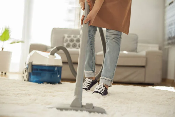 Mulher tapete de limpeza com um aspirador de pó no quarto — Fotografia de Stock