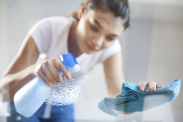 Felice donna casa moglie pulizia tavolo di vetro in casa — Foto Stock