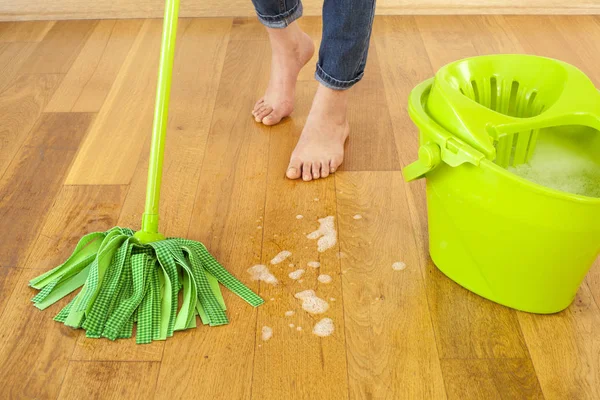 Mulher com suprimentos de limpeza em casa — Fotografia de Stock