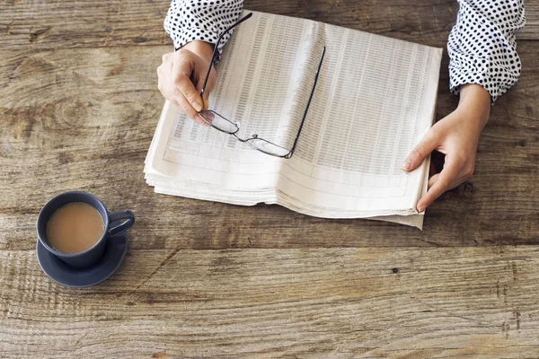 Lectura de periódico en mesa de madera —  Fotos de Stock