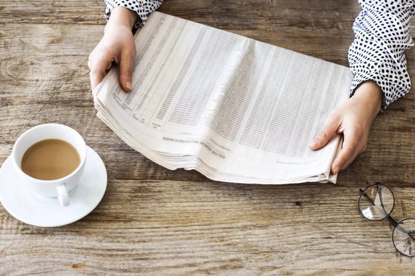 Lectura de periódico en mesa de madera — Foto de Stock