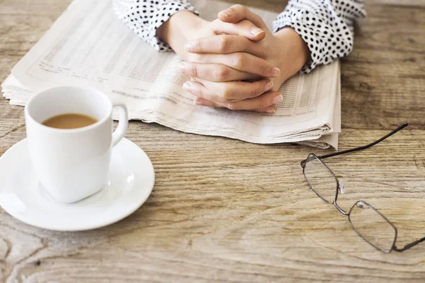 Lectura de periódico en mesa de madera — Foto de Stock