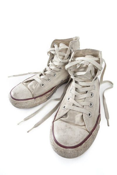 Old white sneakers on white background