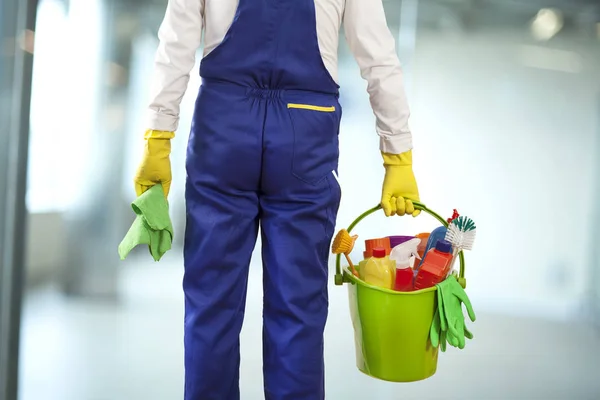 Uomo con prodotti per la pulizia nell'edificio — Foto Stock