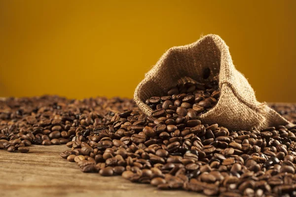 Beans coffee in sack on brown background — Stock Photo, Image
