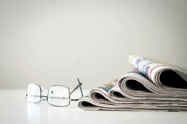 Newspapers with eyeglasses on white background — Stock Photo, Image