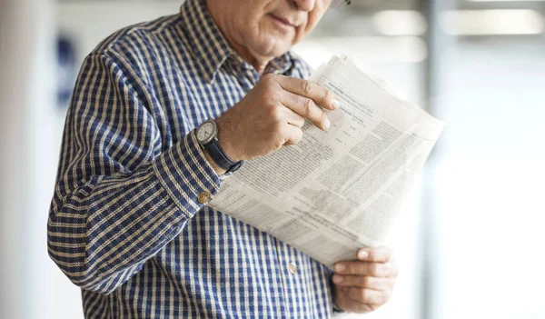 Senior man reading newspaper