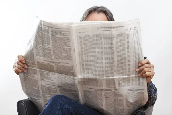 Hombre mayor sentado leyendo el periódico — Foto de Stock