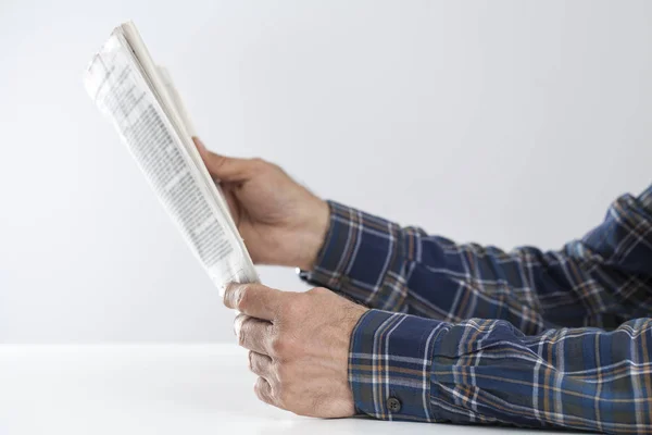 Hombre leyendo el periódico en la mesa —  Fotos de Stock