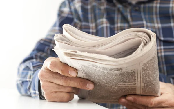 Man reading newspaper on table