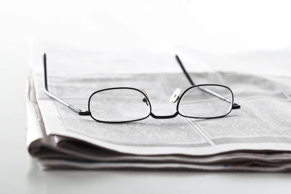 Newspapers with eyeglasses on table — Stock Photo, Image