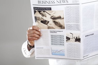 Gri arka plan üzerinde gazete okuyan adam